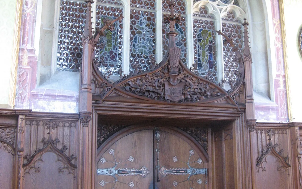 A heavy carved wooden door inside Bouzov Castle